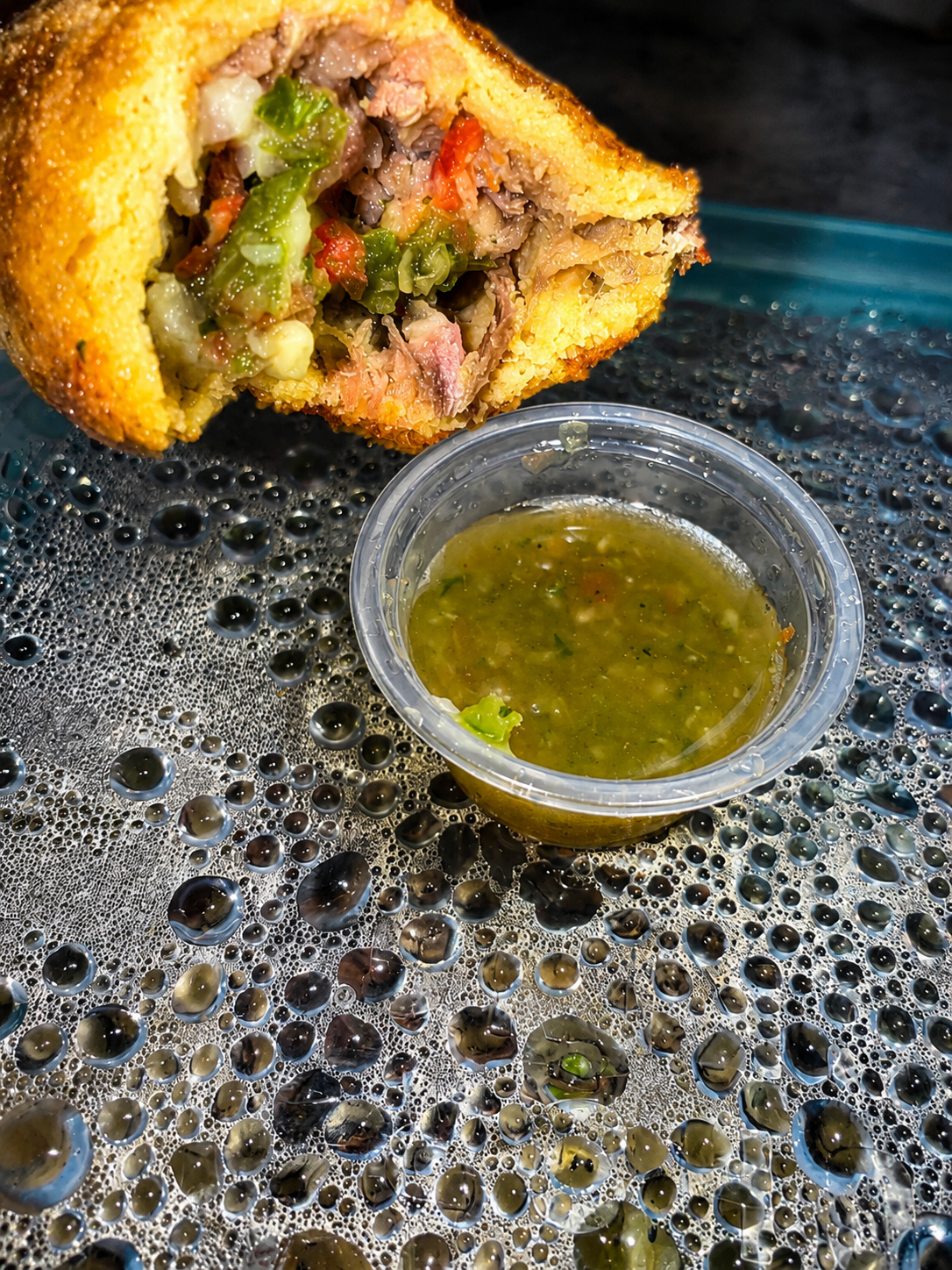 Carne empanada cross-section with green salsa